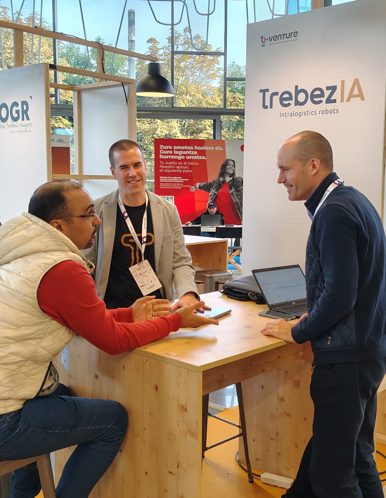 Zerua Tech in conversation at a booth of an AI + robotics company specializing in warehouse robotic-arm technology, exploring applications of automation and AI in industrial logistics.